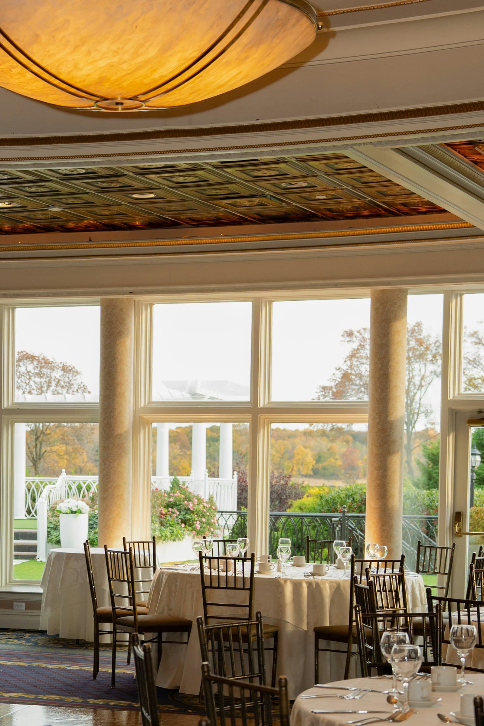 Salón con grandes ventanales dispuesto para un banquete
